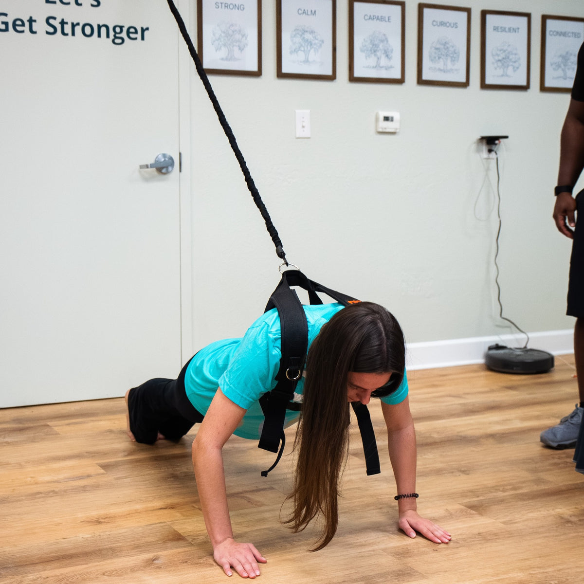 Woman doing a push-up in the PUSH Perfect vest with the cord hooked over a door
