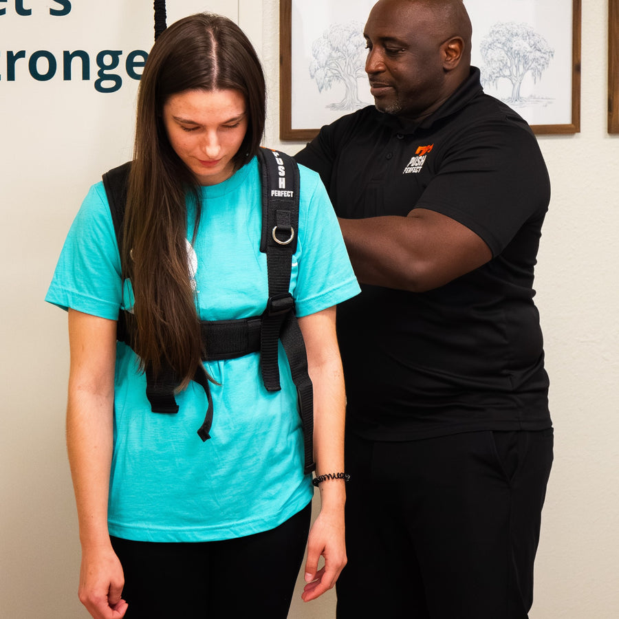 Trainer adjusting the PUSH Perfect vest straps on a woman