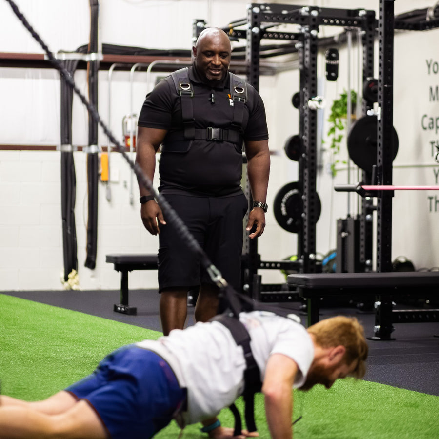 Trainer watching a client do a push-up in the PUSH Perfect vest