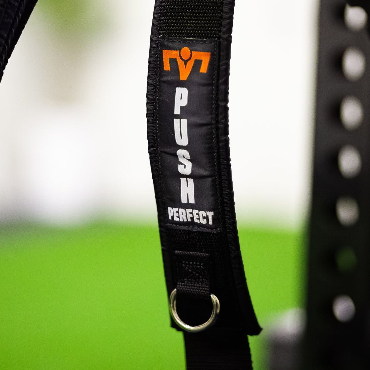 Close-up of the PUSH Perfect shoulder strap with the logo and a metal D-ring